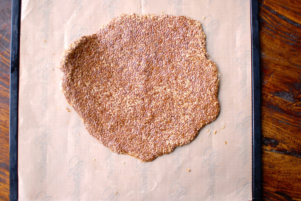 healthy sesame flax seed crackers rolled out on non-stick dehydrator mat 